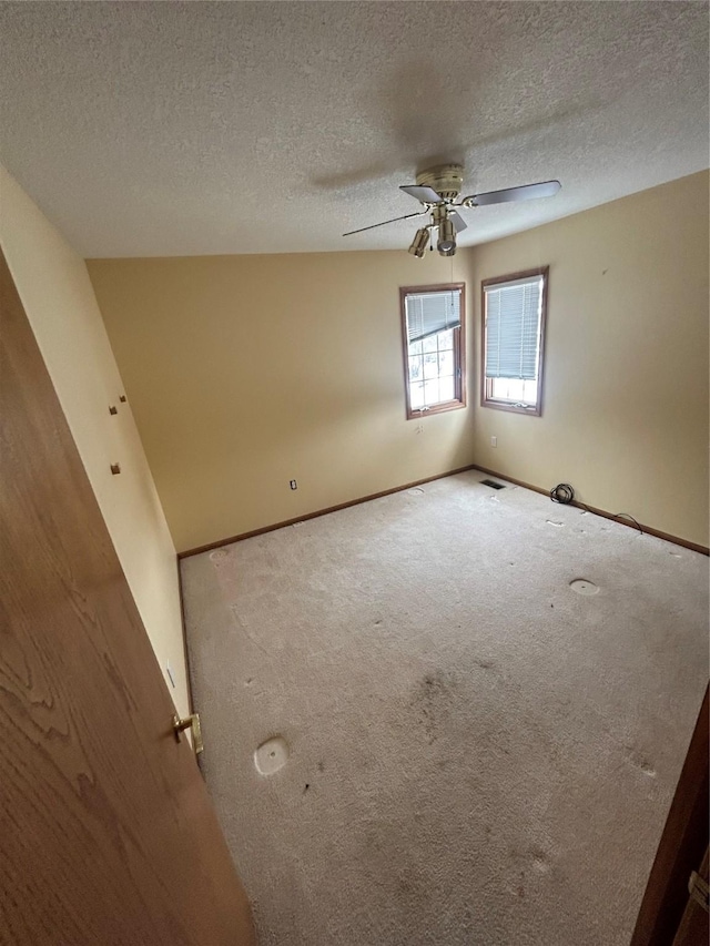 carpeted empty room with a textured ceiling and ceiling fan