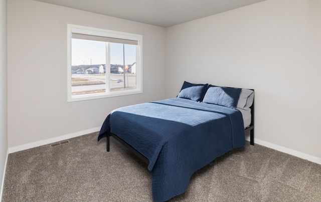 bedroom with dark colored carpet