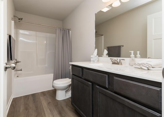 full bathroom with toilet, hardwood / wood-style flooring, shower / tub combo, and vanity