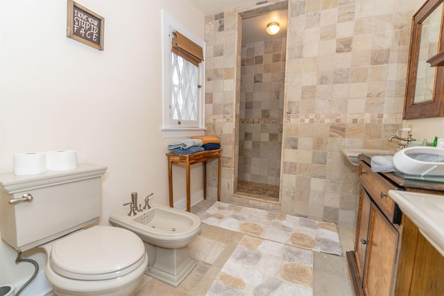 bathroom with a bidet, a tile shower, vanity, and toilet