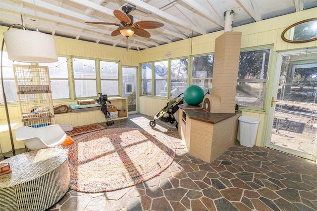 sunroom with ceiling fan and lofted ceiling with beams