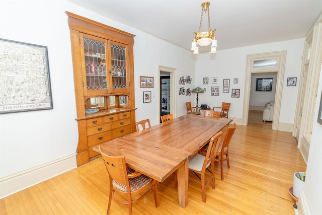 dining space featuring an inviting chandelier and light hardwood / wood-style floors