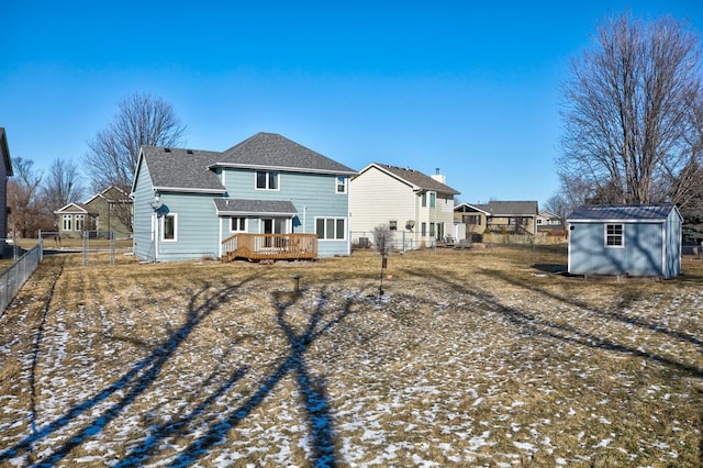 snow covered property featuring a storage unit and a deck