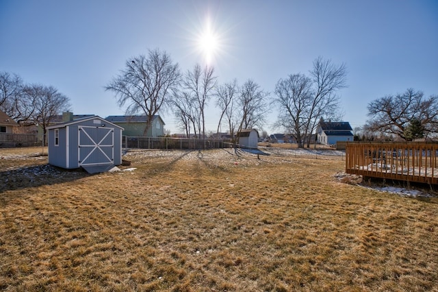 view of yard featuring a deck and a storage unit