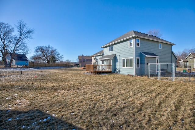 back of property featuring a deck and a yard