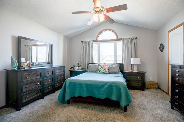 bedroom featuring lofted ceiling, light colored carpet, ceiling fan, and a textured ceiling