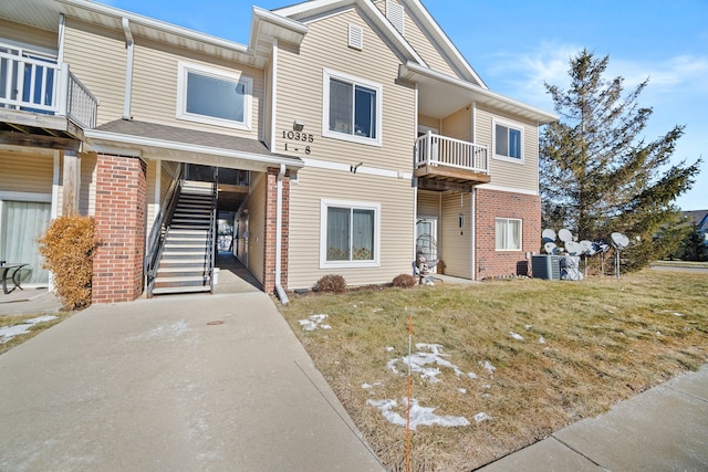 view of property with cooling unit, a carport, and a front yard