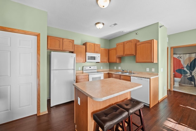 kitchen featuring white appliances, dark wood-type flooring, sink, and a kitchen island