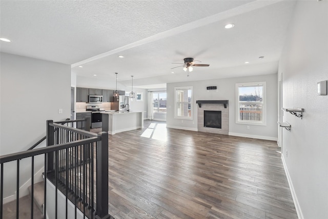 living room featuring sink, dark hardwood / wood-style flooring, ceiling fan, and a wealth of natural light