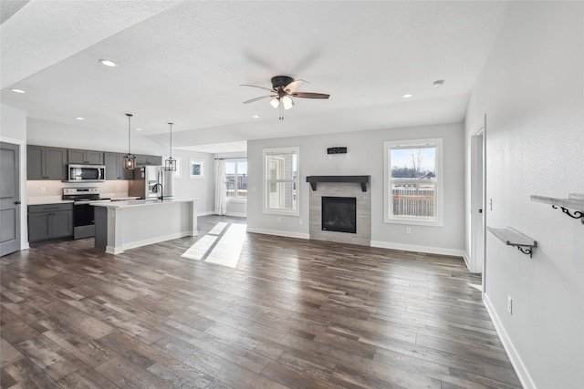 unfurnished living room with ceiling fan, lofted ceiling, and dark hardwood / wood-style floors