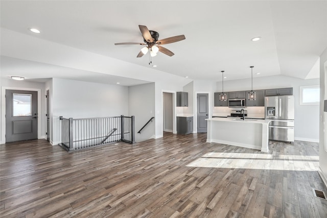 unfurnished living room with lofted ceiling, sink, ceiling fan, and dark hardwood / wood-style floors