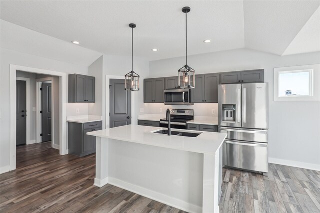 kitchen featuring decorative light fixtures, gray cabinets, vaulted ceiling, and appliances with stainless steel finishes