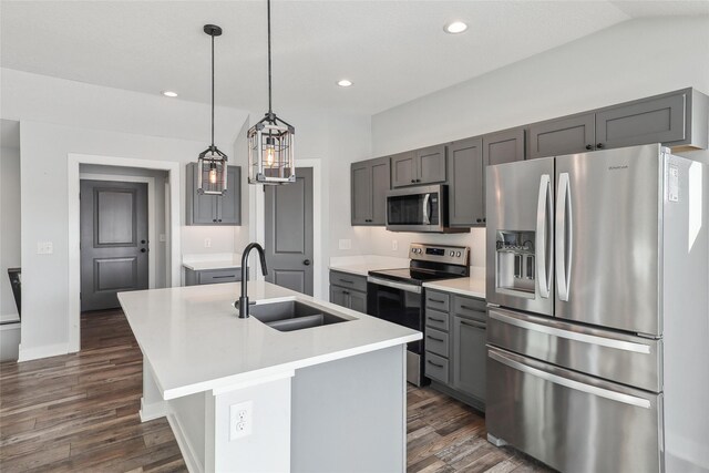 kitchen featuring pendant lighting, a kitchen island with sink, dark hardwood / wood-style flooring, appliances with stainless steel finishes, and sink