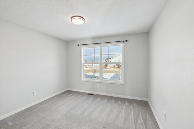 carpeted spare room with a textured ceiling