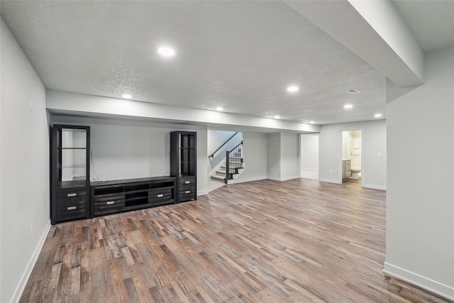 basement with a textured ceiling and hardwood / wood-style flooring