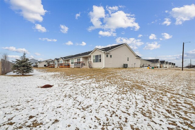 snow covered rear of property featuring a deck and cooling unit