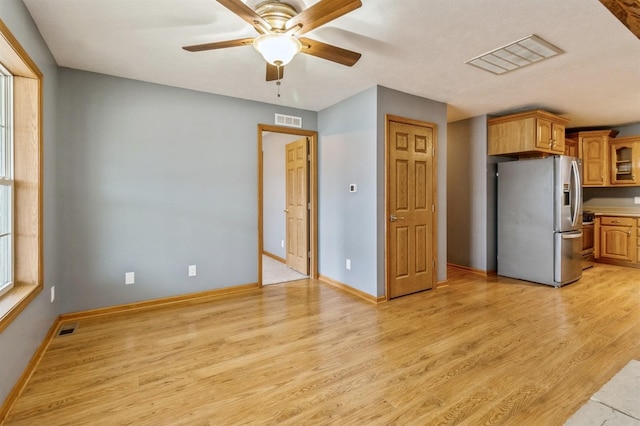 kitchen featuring stainless steel refrigerator with ice dispenser, ceiling fan, and light hardwood / wood-style flooring