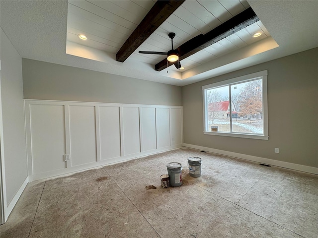 unfurnished room featuring ceiling fan, a raised ceiling, and beam ceiling