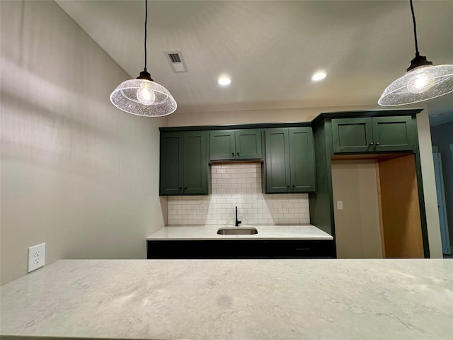 kitchen featuring sink, decorative light fixtures, tasteful backsplash, and green cabinets