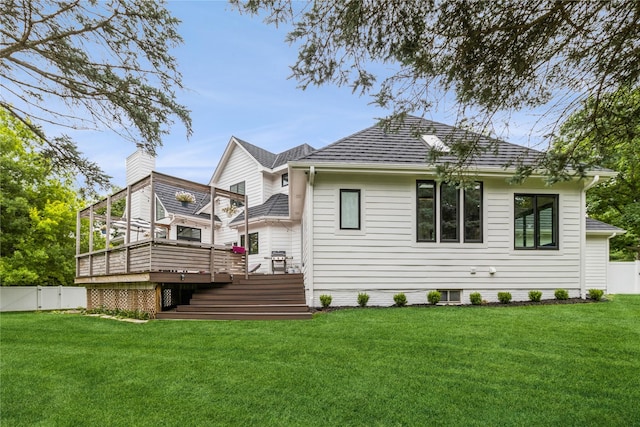 back of property with a yard and a wooden deck