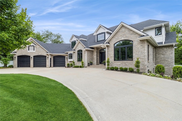 french country style house with a front yard and a garage