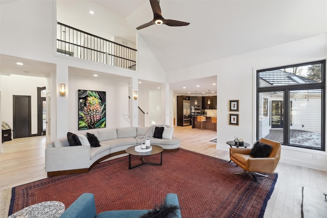 living room featuring high vaulted ceiling, ceiling fan, and light hardwood / wood-style flooring