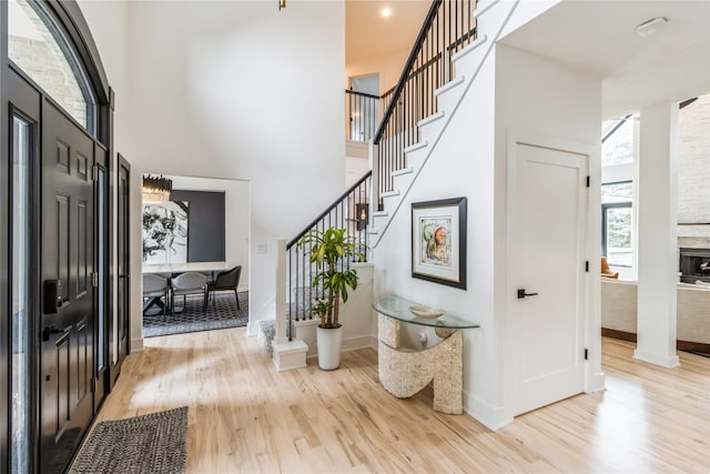 foyer entrance with a towering ceiling and light hardwood / wood-style flooring