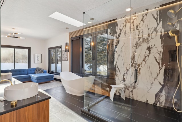 bathroom featuring a tub, a textured ceiling, a skylight, tile patterned floors, and vanity