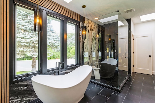 interior space with tile patterned floors, a skylight, and independent shower and bath