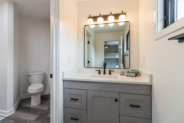 bathroom with toilet, hardwood / wood-style floors, and vanity