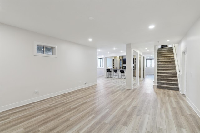 unfurnished living room featuring light hardwood / wood-style floors and bar