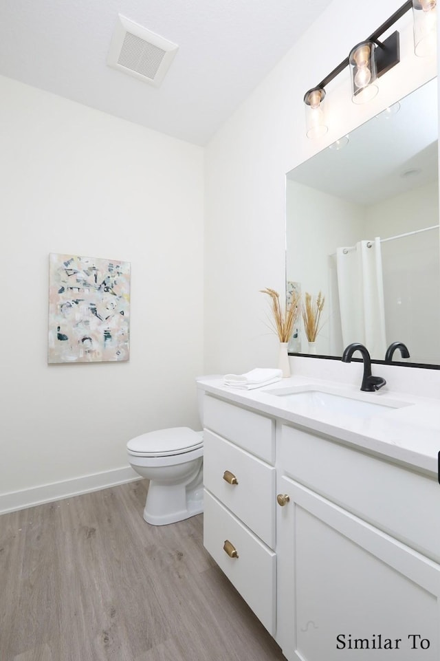 bathroom with a shower with shower curtain, toilet, vanity, and hardwood / wood-style flooring