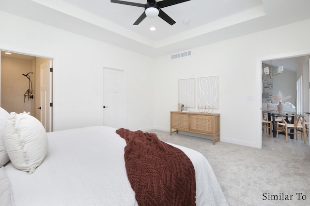 bedroom featuring ceiling fan, light carpet, and a tray ceiling