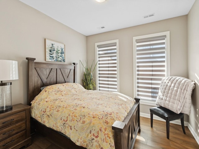 bedroom with multiple windows and hardwood / wood-style flooring