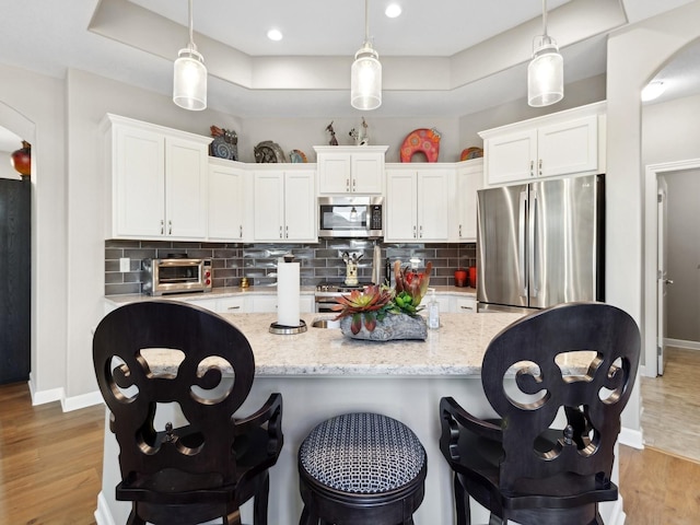 kitchen featuring white cabinets, pendant lighting, and appliances with stainless steel finishes