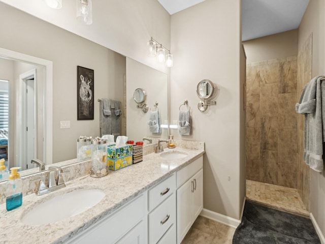 bathroom with tiled shower, tile patterned floors, and vanity