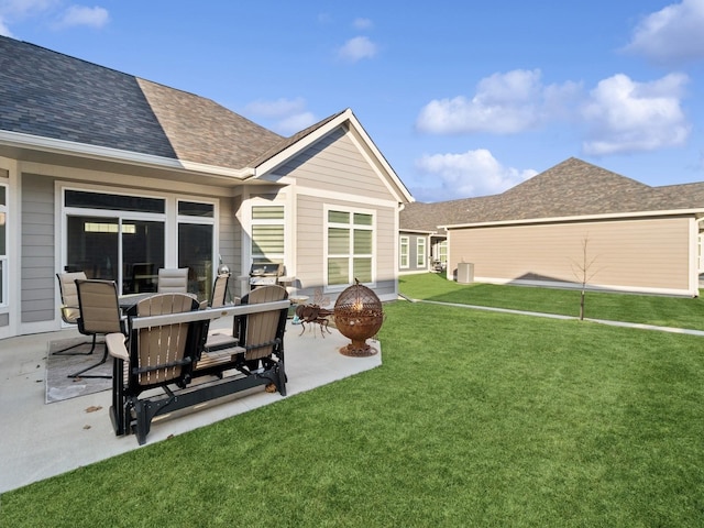 rear view of house with a lawn and a patio