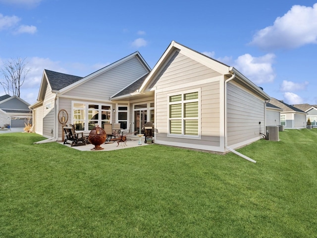 back of property featuring a lawn, a patio area, central air condition unit, and an outdoor fire pit