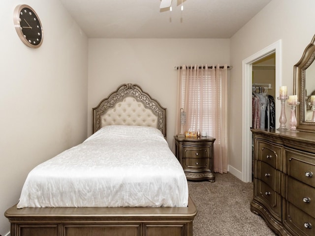 bedroom with a walk in closet, a closet, light carpet, and ceiling fan