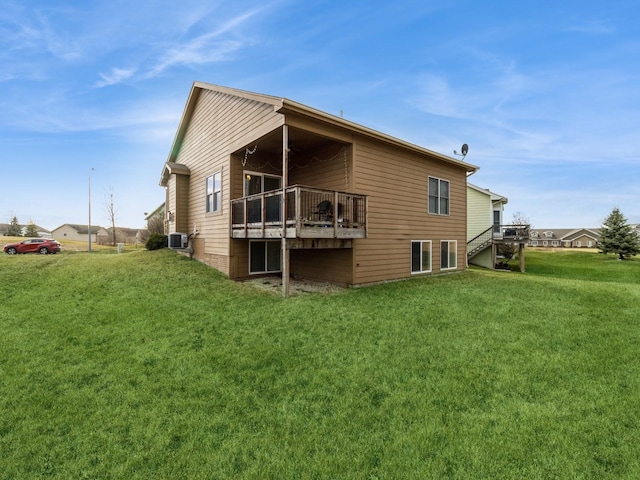 rear view of property with a deck and a yard