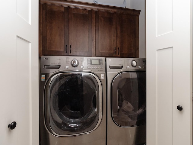 laundry area with independent washer and dryer and cabinets