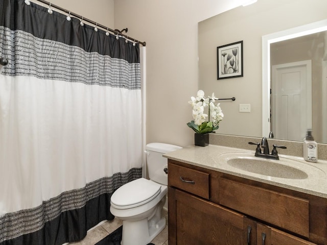 bathroom with toilet, vanity, and tile patterned floors