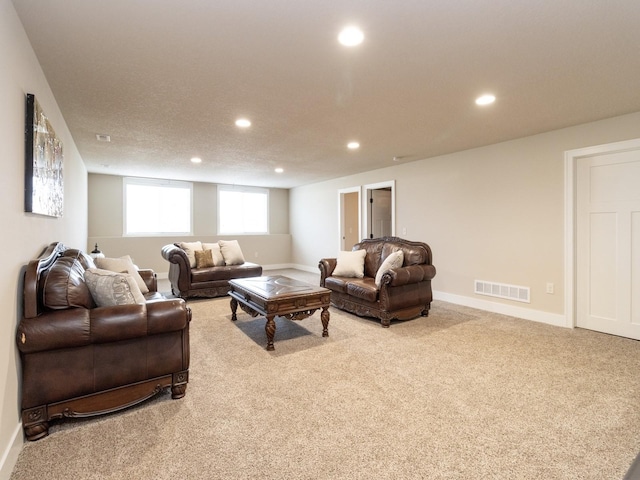 carpeted living room featuring a textured ceiling