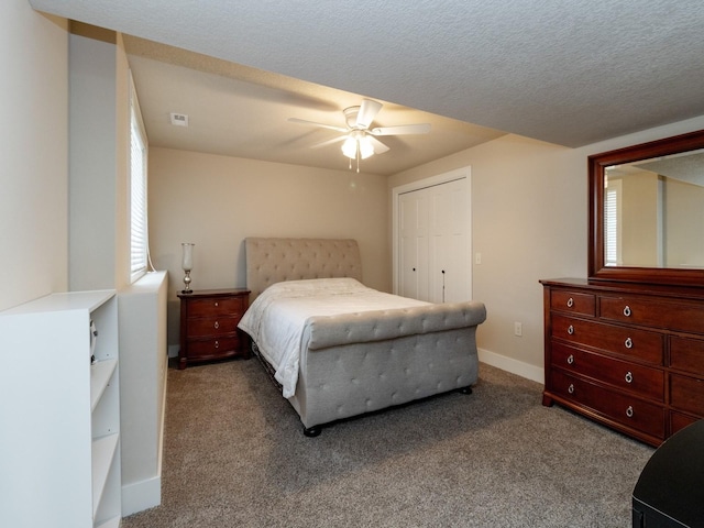 carpeted bedroom with ceiling fan, a closet, and a textured ceiling