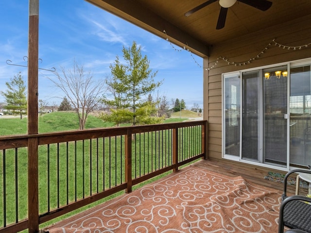 wooden deck with ceiling fan and a yard