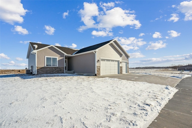 view of front of property featuring a garage and central AC