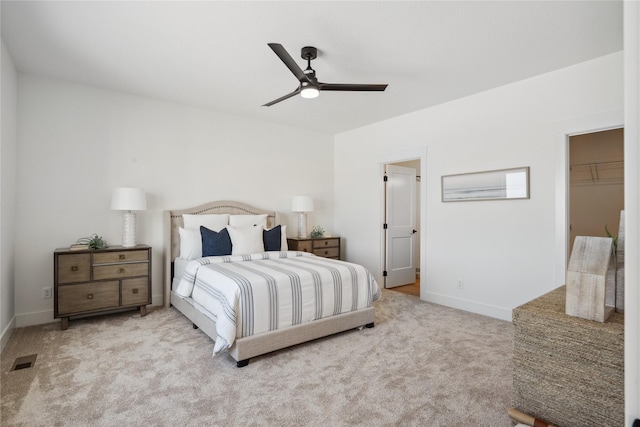 carpeted bedroom with ceiling fan, a walk in closet, and a closet