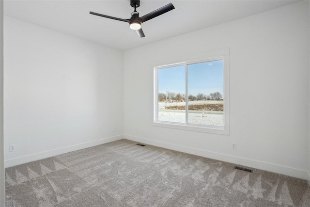 empty room with ceiling fan and light carpet