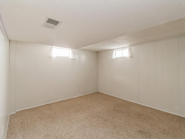 basement with light colored carpet and a textured ceiling