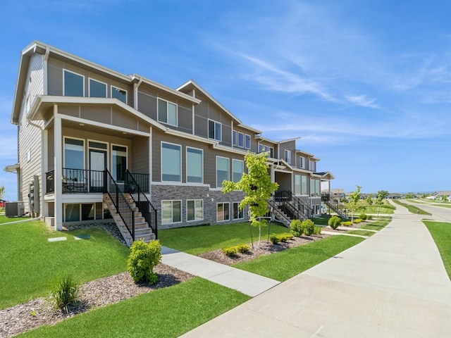 view of front of property featuring central AC and a front yard